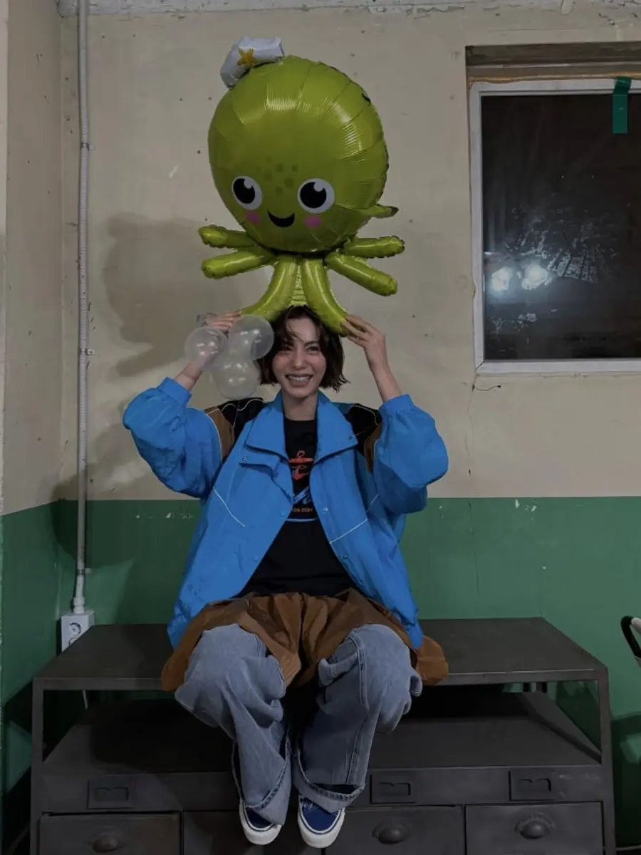 파란색 재킷을 입고 미소 짓는 나나